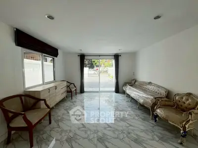 Spacious living room with elegant marble flooring and classic furniture.
