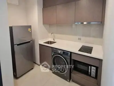 Modern compact kitchen with appliances including fridge, washing machine, and microwave.