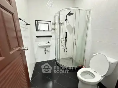 Modern bathroom with glass shower and sleek black flooring