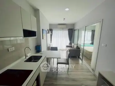 Modern studio apartment with open kitchen and cozy living area, featuring sleek design and ample natural light.