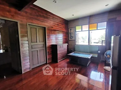 Charming wooden interior living room with polished floors and colorful window accents.