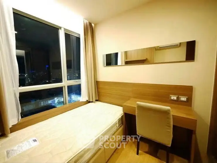 Cozy bedroom with city view, featuring a single bed and study desk, perfect for urban living.