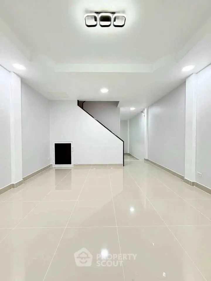 Spacious modern interior with sleek staircase and glossy tiled flooring