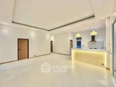 Spacious modern living room with open kitchen and elegant lighting in a luxury apartment.