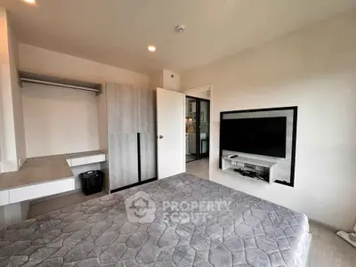 Modern bedroom with built-in closet and wall-mounted TV, showcasing sleek design and functionality.