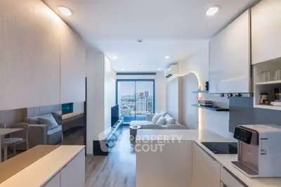 Modern open-layout living room with kitchen, featuring sleek design and city view.