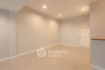Spacious empty room with neutral tones and recessed lighting, perfect for customization.