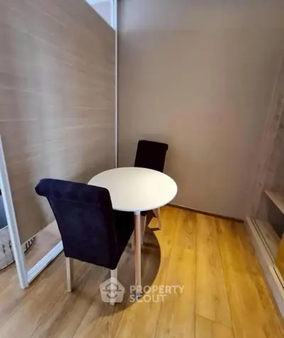 Cozy study nook with round table and two chairs on wooden flooring