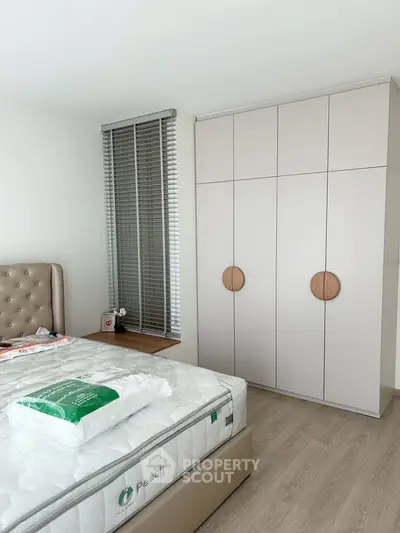 Modern bedroom with stylish wardrobe and comfortable bed in a bright, minimalist design.