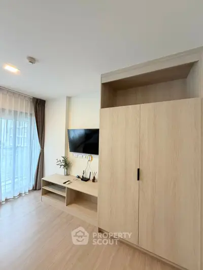 Modern living room with sleek wooden furniture and large window for natural light.