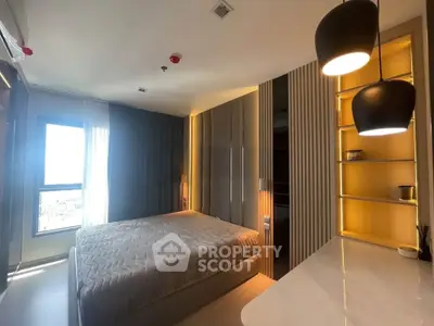 Modern bedroom with stylish lighting and large window offering natural light.