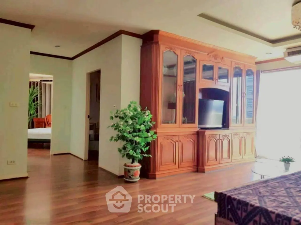 Spacious living room with elegant wooden cabinetry and natural light