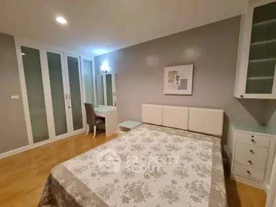 Spacious bedroom with elegant decor and ample storage in modern apartment.