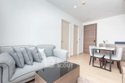 Modern living room with cozy sofa and dining area in bright apartment.