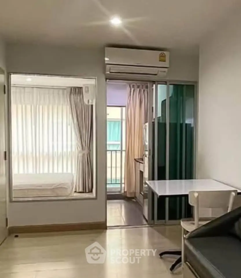 Modern apartment interior with compact layout, featuring a small bedroom, kitchen, and living area.