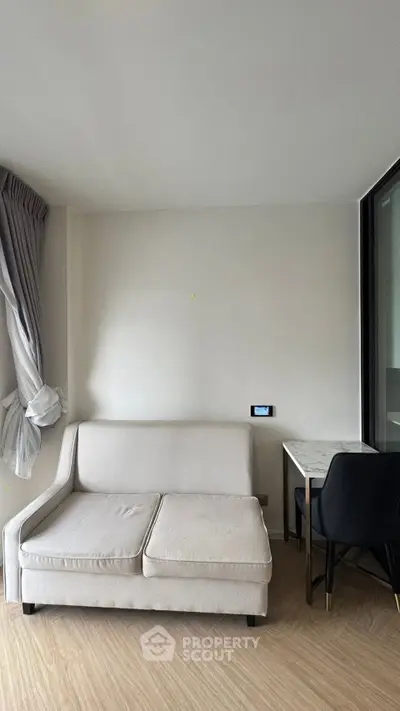 Modern living room with sleek sofa and stylish desk in a bright apartment.