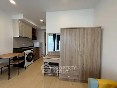 Modern studio apartment with compact kitchen and washing machine