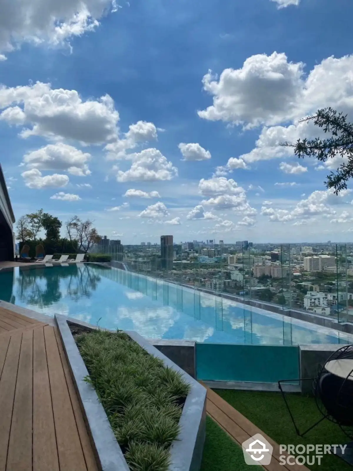 Stunning rooftop infinity pool with panoramic city views and lush greenery.