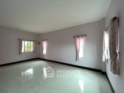 Spacious empty room with tiled floor and natural light from windows