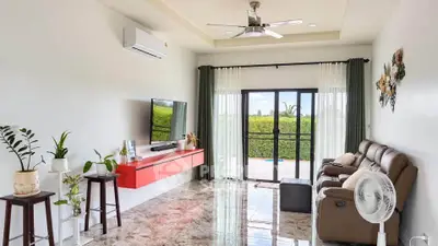Spacious living room with modern decor and large windows offering garden views.