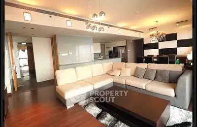 Spacious modern living room with elegant decor and open kitchen layout.