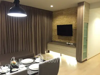 Modern living room with elegant dining setup and wall-mounted TV