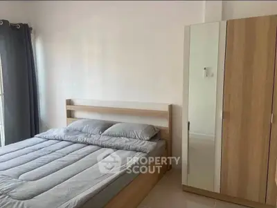 Modern bedroom with sleek wooden furniture and ample natural light.