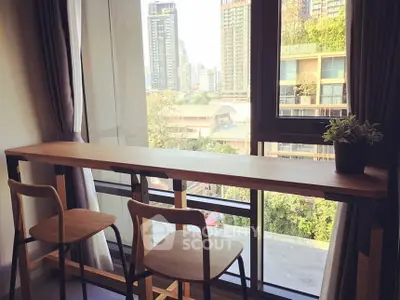 Modern apartment with city view and stylish bar seating by the window.