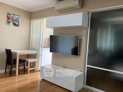 Modern living room with wall-mounted TV and sleek furniture in a cozy apartment.