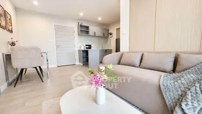 Modern living room with cozy beige sofa and stylish kitchen in open layout apartment.