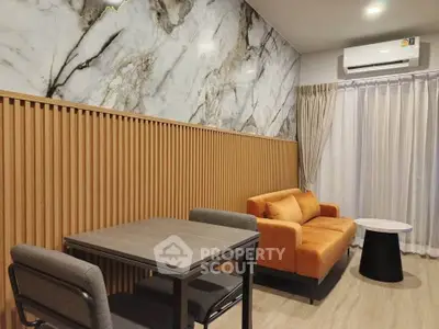 Modern living room with marble accent wall and vibrant orange sofa