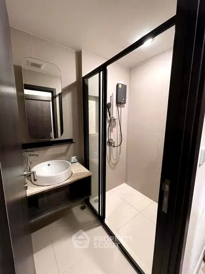 Modern bathroom with sleek shower enclosure and stylish vanity in contemporary apartment.