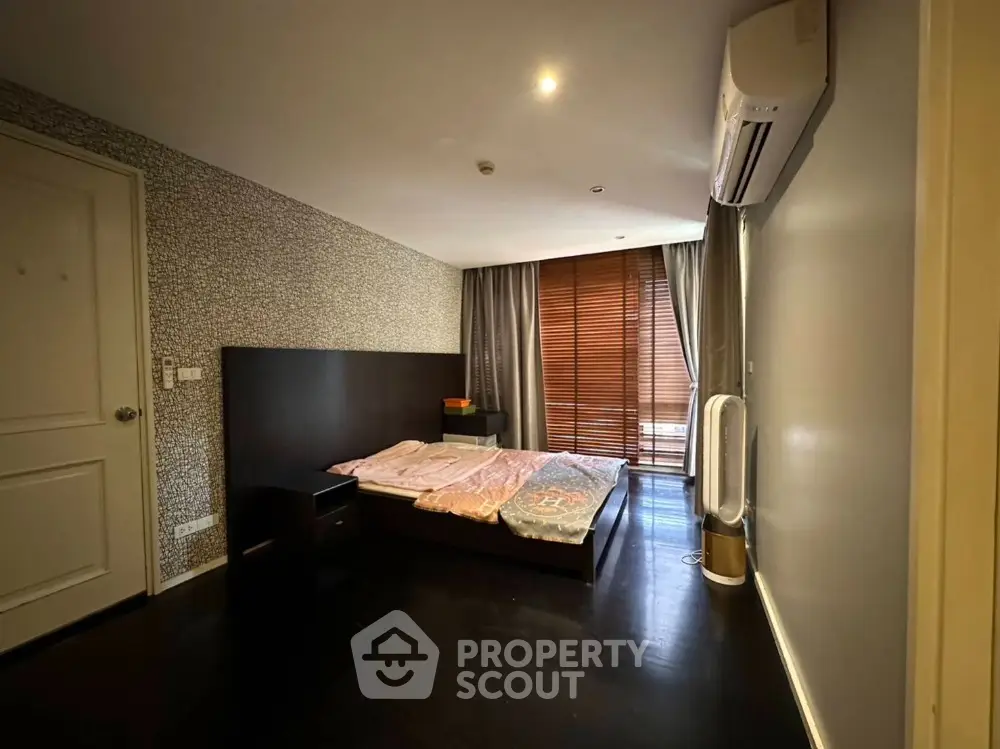 Spacious bedroom with modern decor and large window for natural light