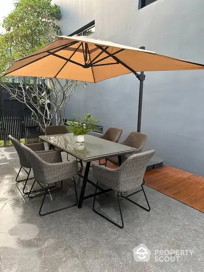 Chic outdoor patio with modern furniture and umbrella, perfect for entertaining.