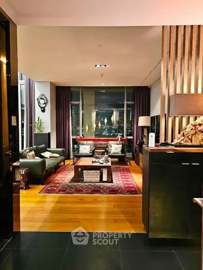 Luxurious living room with elegant decor and stunning city view, featuring plush seating and ambient lighting.