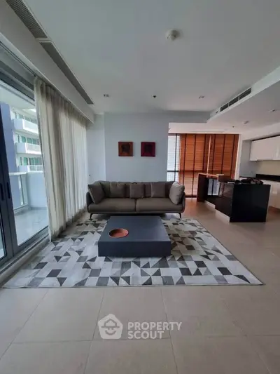 Modern living room with stylish sofa and geometric rug in open layout apartment