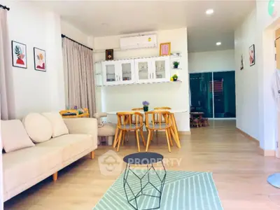 Charming living room with modern decor and cozy seating area, perfect for relaxation and entertaining.