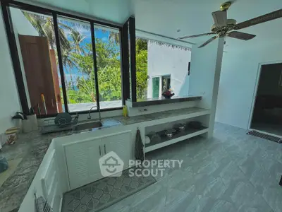 Spacious kitchen with open layout and stunning tropical view, perfect for culinary enthusiasts.
