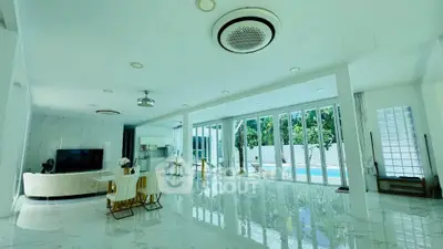 Luxurious open-plan living room with pool view and modern decor