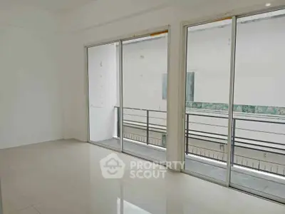 Spacious empty room with large sliding glass doors leading to a balcony, perfect for natural light.