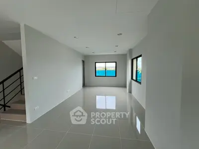 Spacious modern living room with large windows and glossy tiled floors