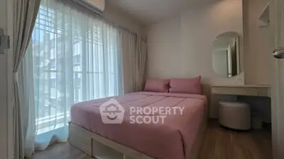 Cozy bedroom with pink bedding and natural light through sheer curtains