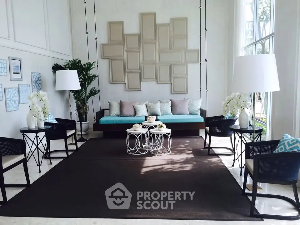 Elegant living room with modern decor and large windows, featuring stylish furniture and ambient lighting.