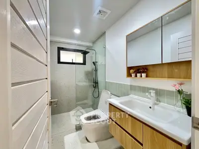 Modern bathroom with sleek design, featuring a glass shower and stylish vanity.