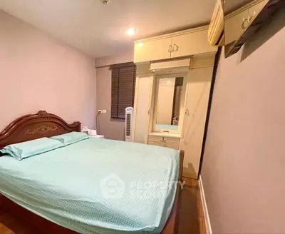 Cozy bedroom with elegant wooden bed and built-in wardrobe, perfect for restful nights.