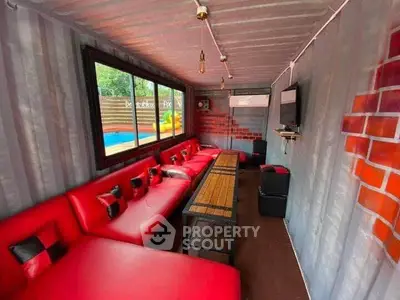 Unique container living room with vibrant red seating and modern decor