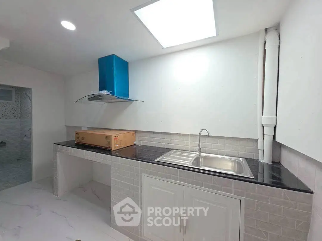 Modern kitchen with sleek black countertop and stainless steel sink
