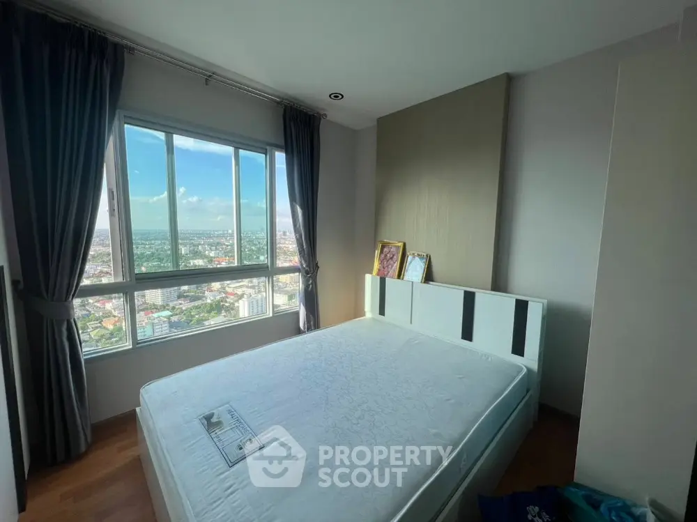 Bright bedroom with large window offering stunning city views