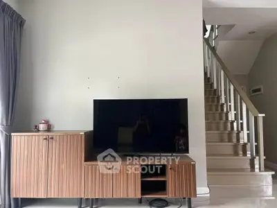 Modern living room with sleek TV stand and staircase, perfect for contemporary home design.