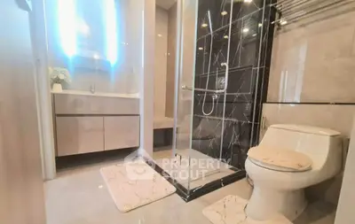 Modern bathroom with sleek shower and elegant vanity in luxury apartment.